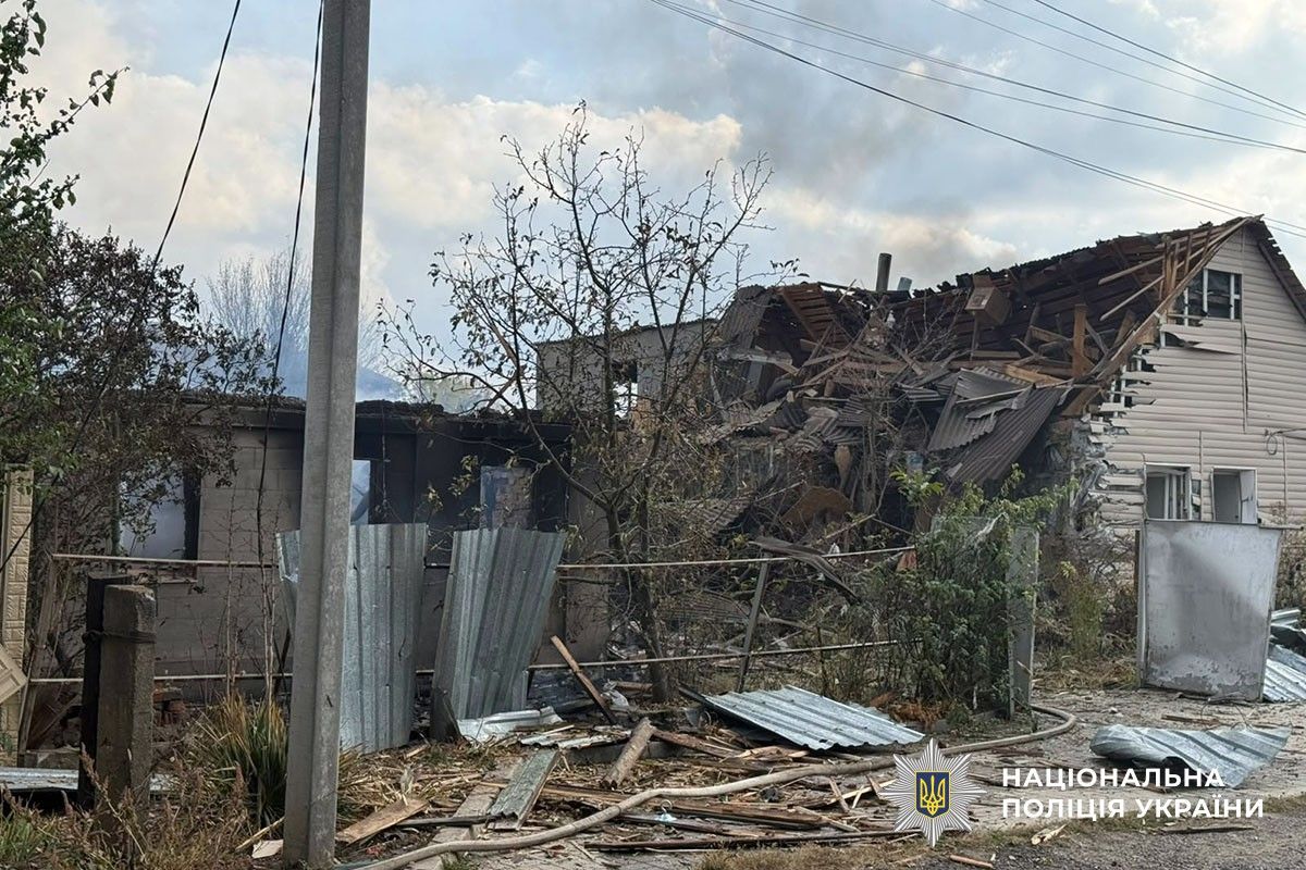 Приватний будинок із сильно пошкодженим дахом та уламки будівельних конструкцій у дворі.